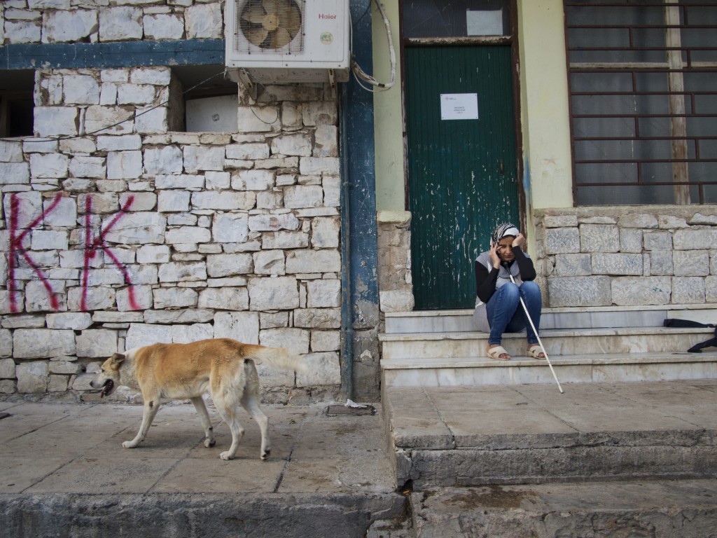 Jihan sits in the courtyard of Lavrion camp in Greece, talking on the phone with her husband, who has received asylum in Denmark. Wiping her tears, she shares with him her worries about the children’s education and reuniting the family. Photo by UNHCR/A. D’Amato/2014.