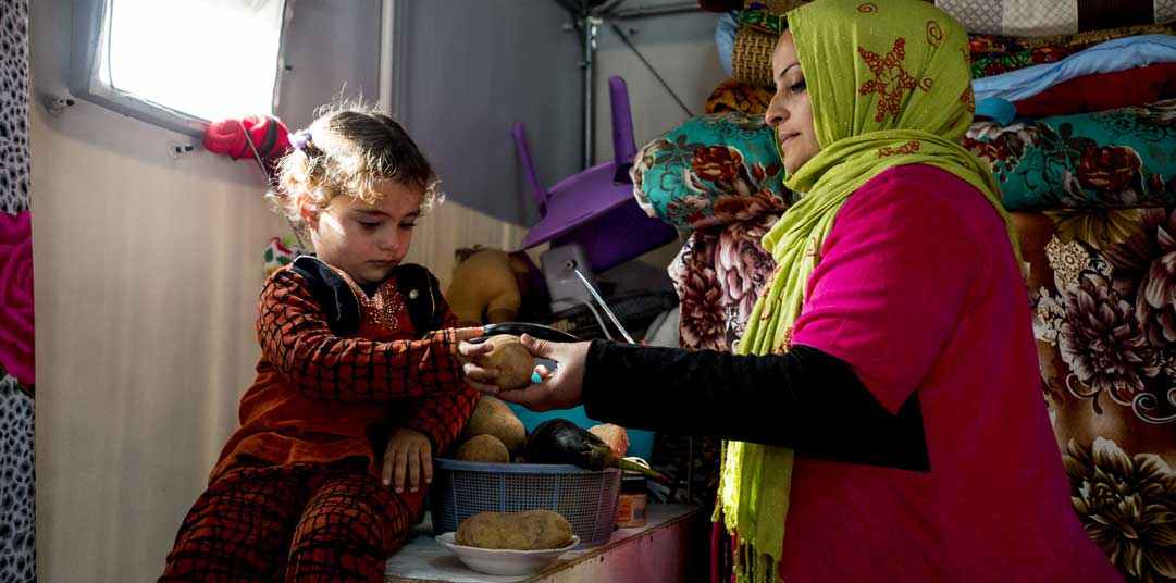Hind and her five-year-old daughter in their new refugee housing in Al Jamea’a camp, Baghdad 