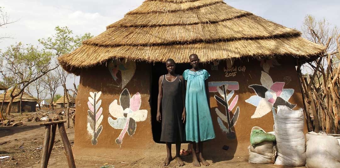 Nyakong and her daughter outside the hut they built in an Ethiopian camp
