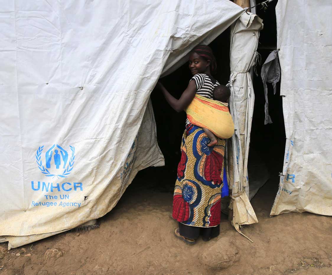 A young woman enters her shelter in Uganda