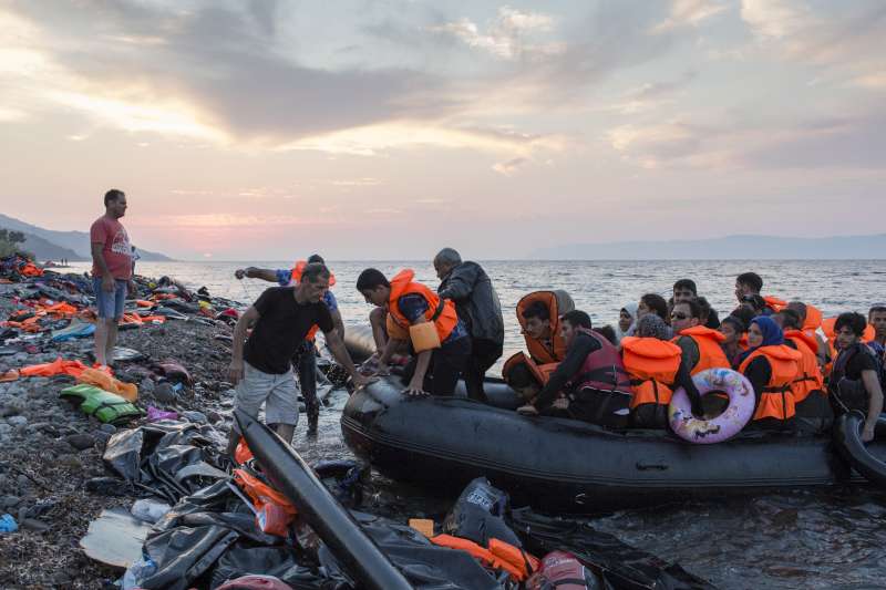 At sunset a group of mostly Syrian refugees arrive on the Greek island of Lesvos after crossing the Aegean Sea from Turkey. 