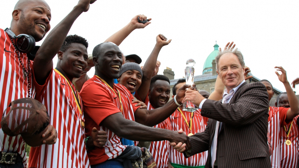 Former Republic of Ireland football manager, Brian Kerr, presenting the winner's trophy to KASI at the Fair Play Football Cup 2013