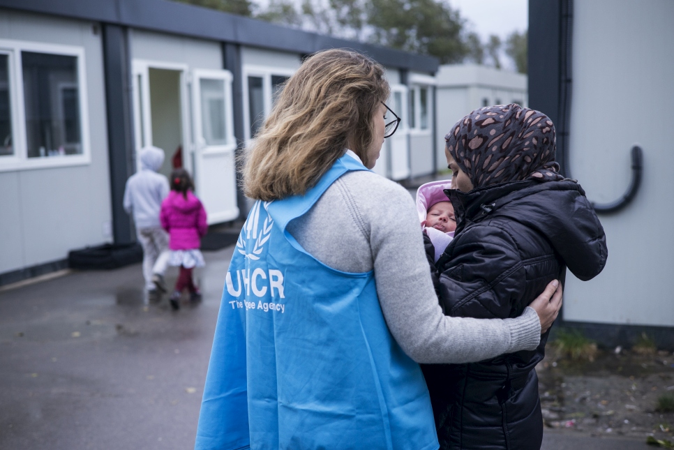 Une employée du HCR réconforte une mère et son enfant à Calais, quelques jours avant le démantèlement.