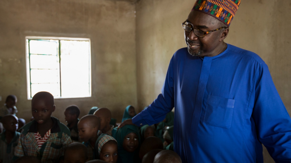 Mustapha surrounded by students in one of the nursery classes.