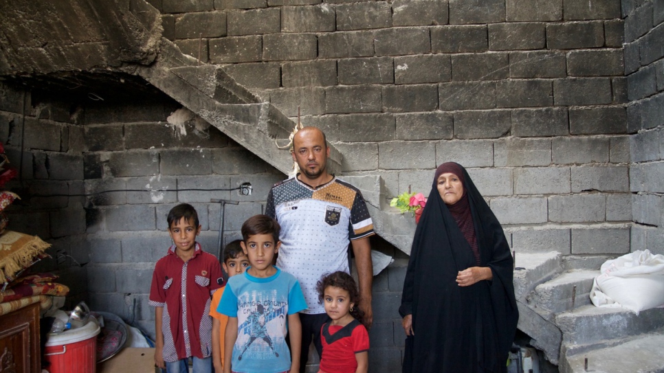 Father of six, Ammar Sajit Mutlaq, 40, and his family stand inside their damaged home, scorch marks still visible on the walls.