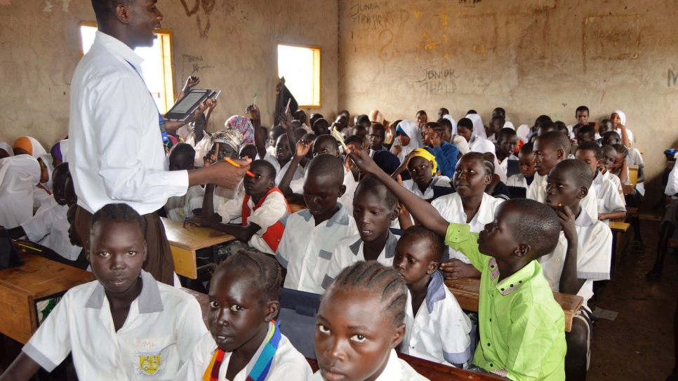 A teacher uses a tablet from the INS kit to teach students.