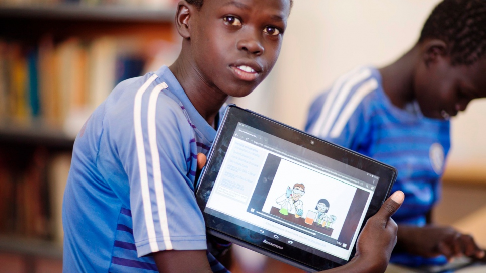 Paul uses a tablet to read at Kakuma refugee camp in Kenya.