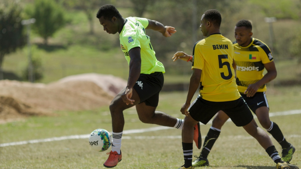 Benin (in yellow) and Togo (in green) clash in the first round of the Refugees World Cup at CERET Park, Sao Paulo, Brazil.