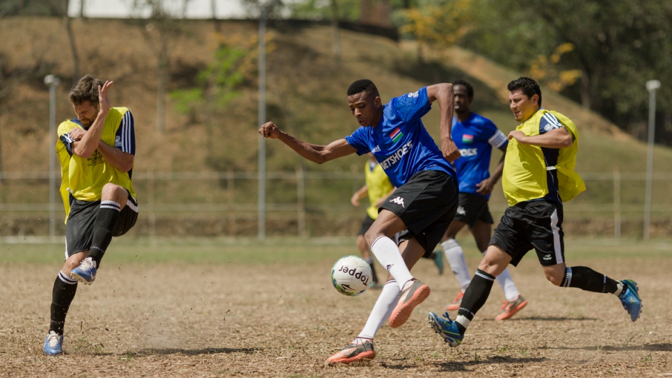 Colombia (in blue) and Gambia (in yellow) go head to head in a first round match at the Refugees World Cup in CERET Park, Sao Paulo, Brazil.