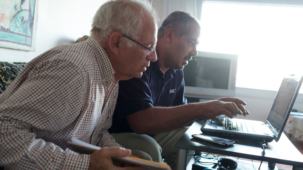 David Friendly assists Ahmad Ayash with paperwork that Ahmad hopes will allow him to privately sponsor members of his own family and bring them to Canada.