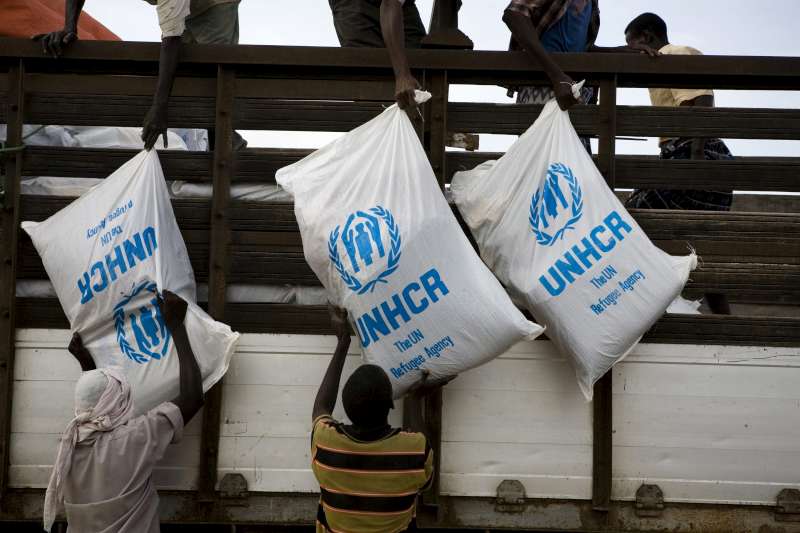  Aid items are unloaded from a truck at the Al Adala settlement, Somalia, 2011