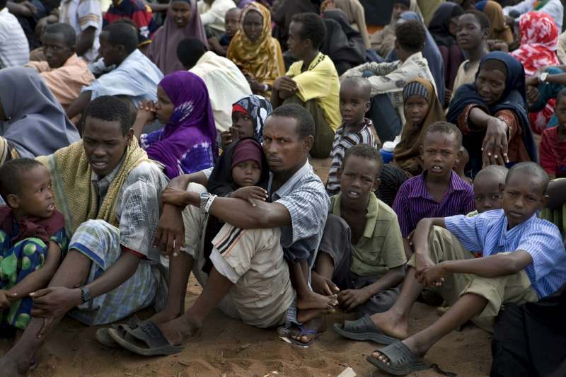  Refugees waiting to be registered sit in front of the UNHCR registration offices at Dadaab camp, 2010