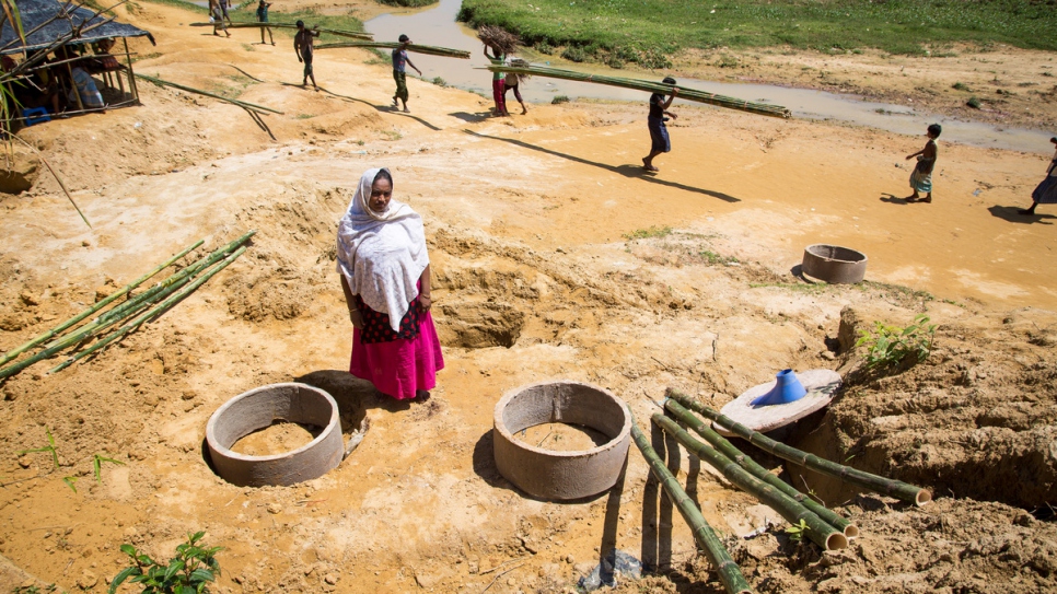 Abdula Hakim stands next to the field latrines being set up near her shelter.
