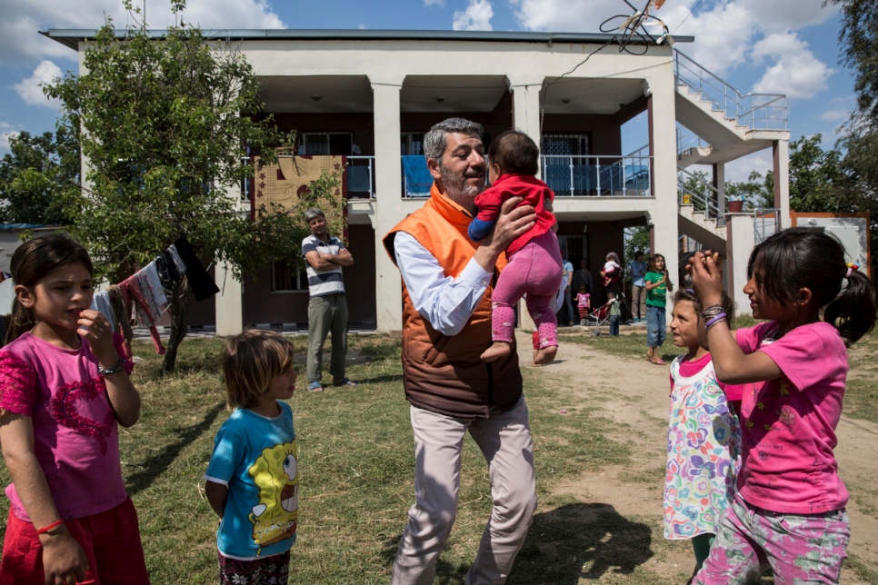 Levent Topçu plays with young Syrian refugees at the accommodation he provided for them, in Torbali, Turkey.   © UNHCR/Andrew McConnell