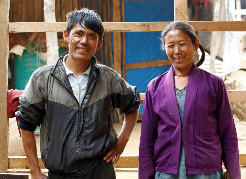 Jagat Lama and his wife Dawa Sangmo take a break from rebuilding their earthquake levelled home in Baramchi Village, Nepal.