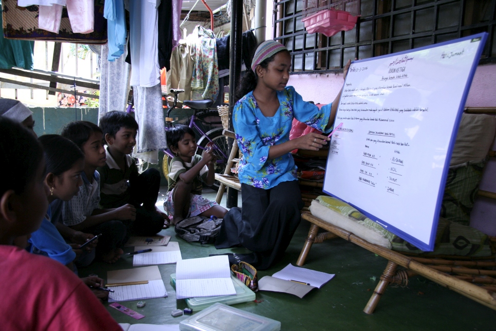 On the weather-beaten porch of a small terrace house in the town of Kelang, 13-year-old Rohingya refugee Jamilah gives a lesson on Islamic studies. Her community can neither afford to hire a teacher nor send their children to public schools in Malaysia.