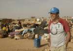 In Kounoungo camp, UNHCR Goodwill Ambassador Julien Clerc witnesses the arrival of a convoy with Sudanese refugees from a temporary site in the volatile border area on March 3, 2004.