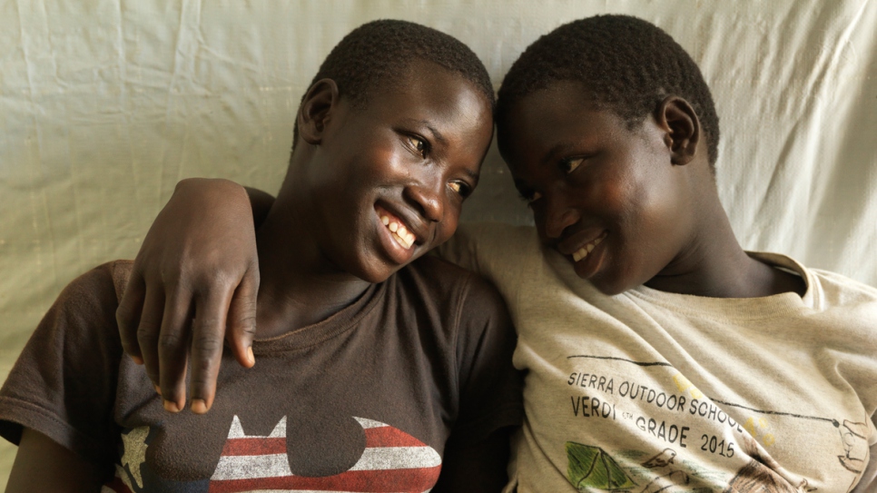 Tabu (left) relaxes with her twin sister, Rena, in their shelter.