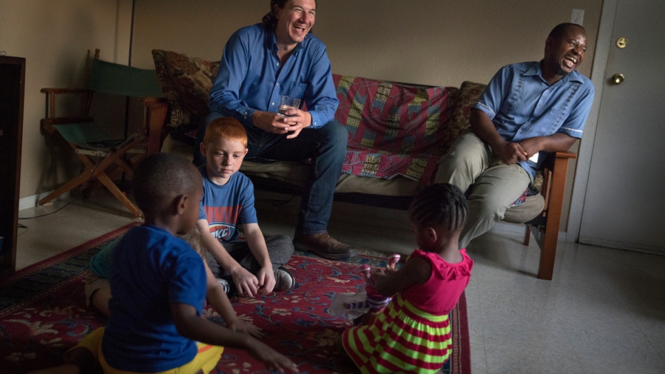 Cobi Cogbill, 31, (left) and Majidi, 36, hang out as their children play together at his house in Fayetteville, Arkansas. They have become best friends since meeting. 
