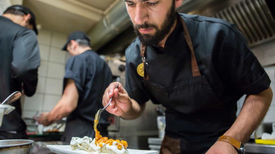 Afghan chef Reza Golami cooks in the kitchen of the It restaurant in Bari, Italy.