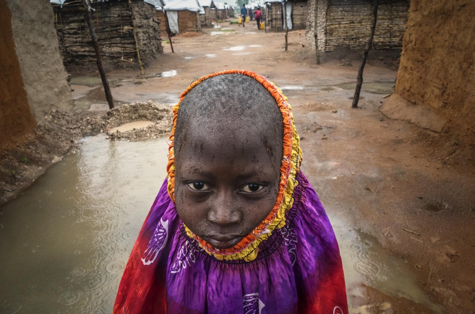 Kibowa, 10, stands between newly erected shelters in the Kanteba IDP site, Katanga Province, DRC. He and his family fled their village when it came under attack by the Mai Mai Bataka Katanga rebel militia.