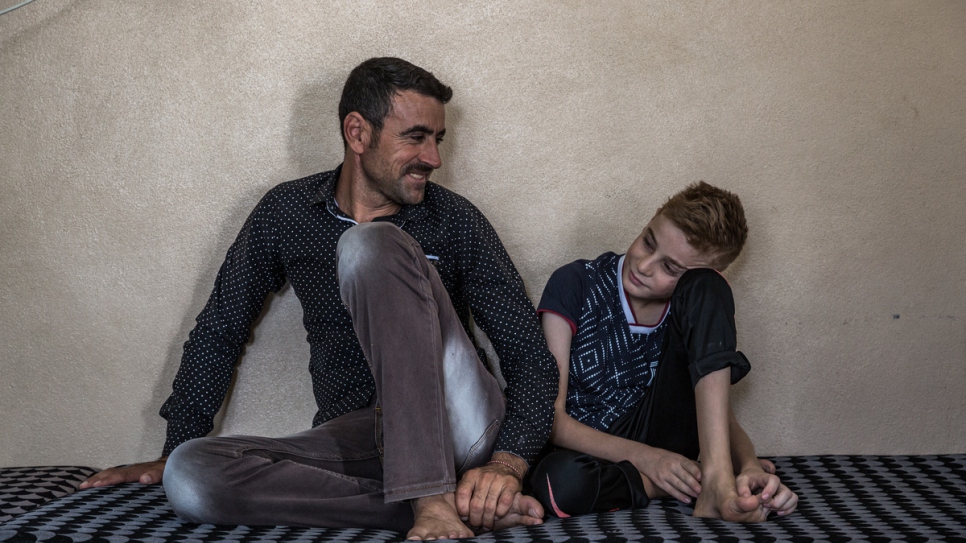 Hadi Tammo, 31 ans, est assis avec son neveu Emad dans une maison à Dohouk, dans la région du Kurdistan d'Iraq.