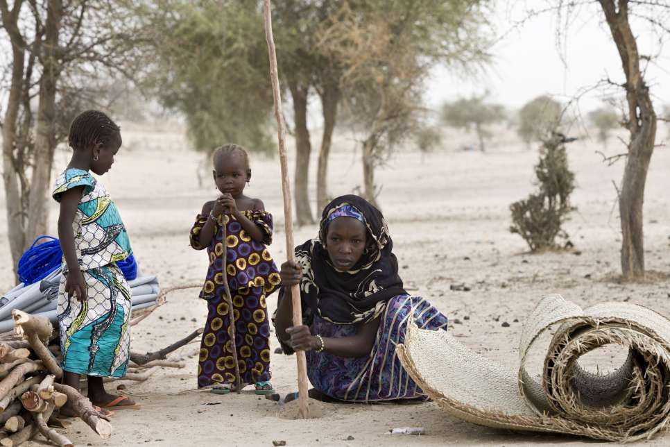 Nigerian refugee Boussam installs a pole to start building a shelter in Sayam Forage camp, in Niger’s Diffa region.  © UNHCR/Hélène Caux