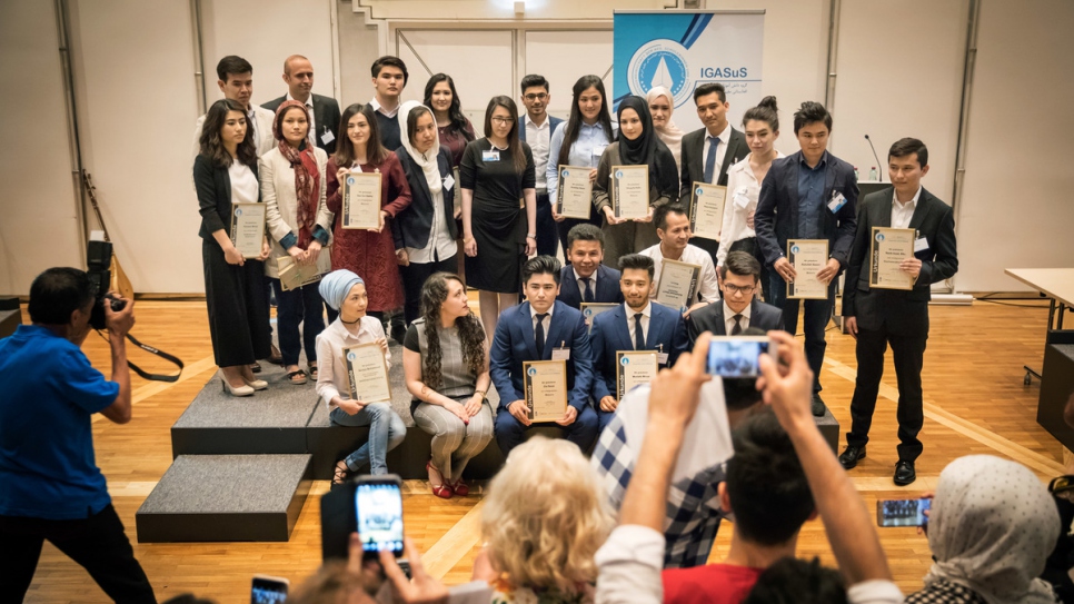 Les lauréats présentent leurs certificats lors d'une cérémonie organisée par l'Association des élèves et étudiants afghans à Vienne. 