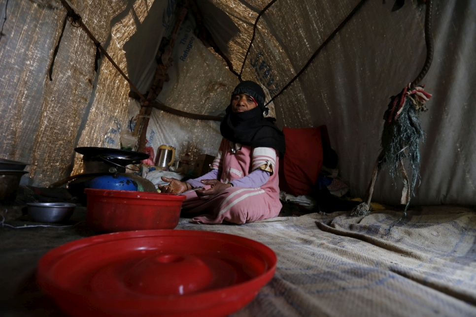 Zahrah, a widow and mother of eight displaced by war, sits in a makeshift shelter in Sana’a, Yemen.  © UNHCR/Mohammed Hamoud