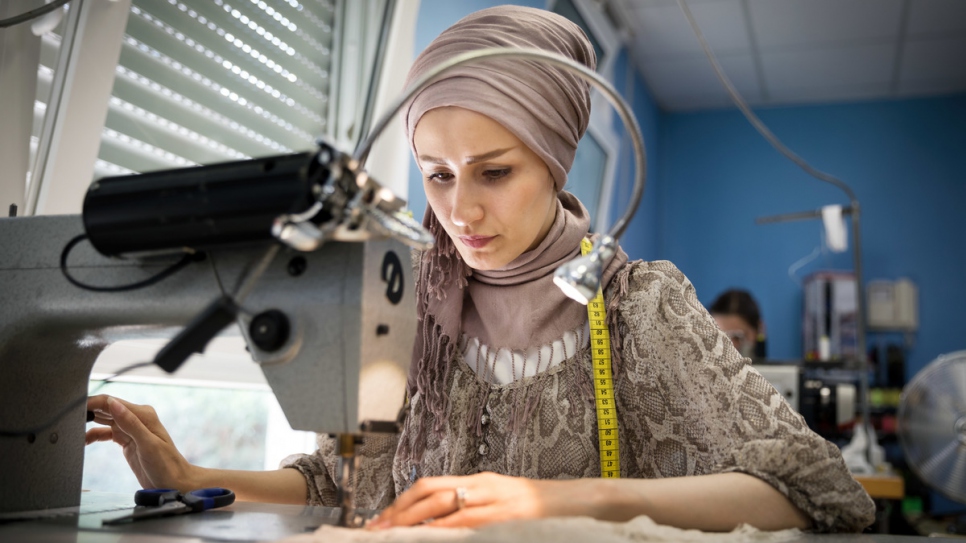 Reyhane, qui a fui l'Afghanistan, en train de coudre à l'atelier. 