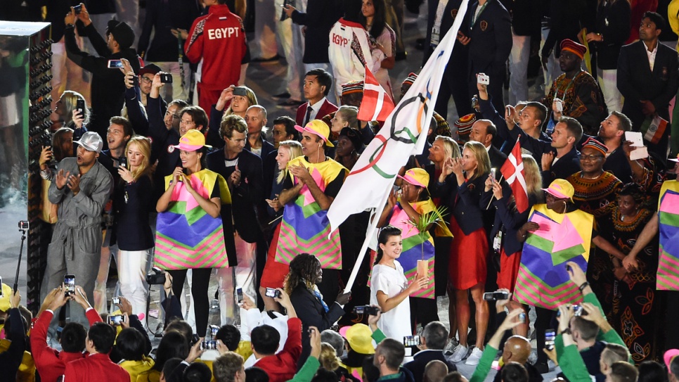 Rose, carrying the flag, leads the other members of the Refugee Olympic Team at the Opening Ceremony. © UNHCR/Benjamin Loyseau