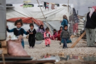 Young Syrian refugees walk through an informal settlement in the Bekaa Valley.  © UNHCR/Sam Tarling