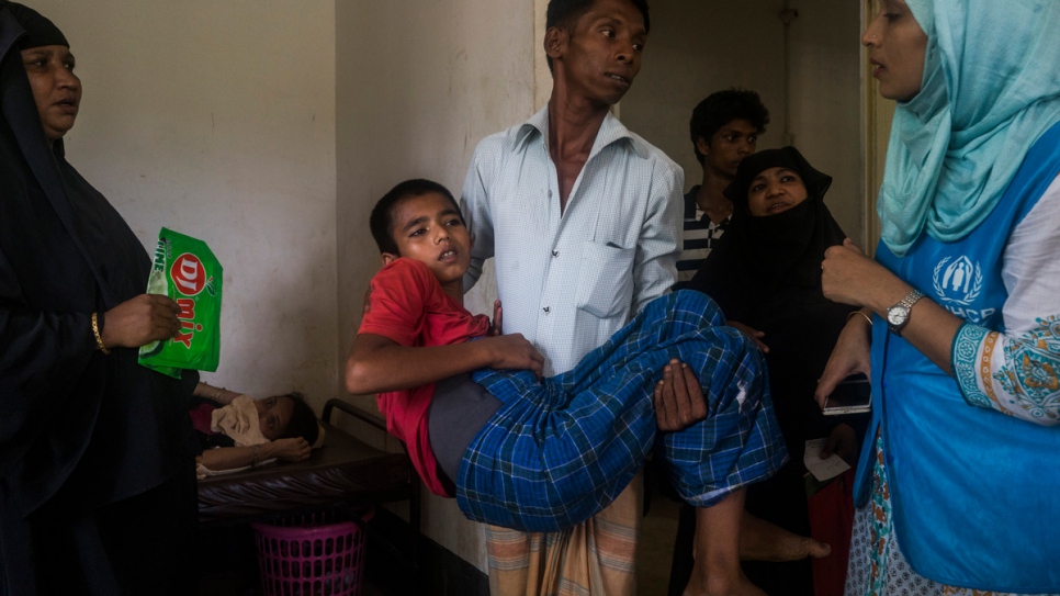 Hubaib, 12, a Rohingya refugee from Myanmar is carried into a room at a UNHCR funded Refugee Health Unit in the Kutupalong Refugee Camp in Kutupalong, Bangladesh. Hubaib was shot in the back and his father was shot and killed.