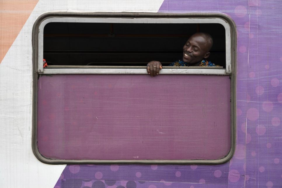 A former Angolan refugee looks out the window of a train on the platform at Kinshasa Est station in DRC. Soon, he will begin his journey home to Angola.