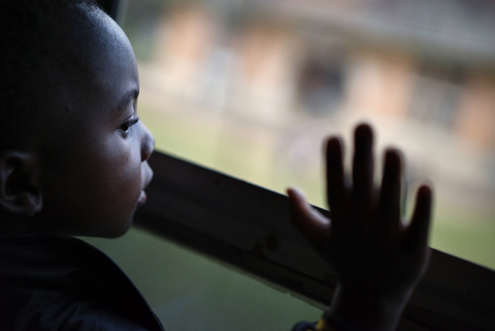 A girl waves from the train as it pulls out of the station in Kinshasa and heads to Angola. For many of the former refugees on board, it will be the first time they have visited their homeland.