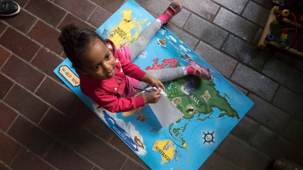 Dina plays on the floor of her home in Antwerp, Belgium, where she lives with her parents.