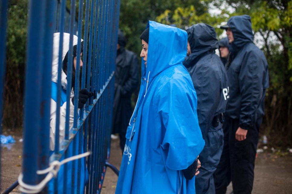 UNHCR protection officer Hana (right) talks to her colleague Diana through the border fence while waiting for a new group of refugees to arrive from Serbia to Bapska, Croatia.