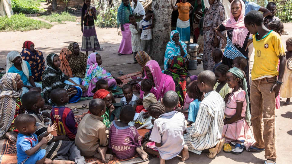 Samira Hassan (in pink shawl) sits with one of her daughters and other members of the community which welcomed her in Chad after she and her children fled violence in CAR in 2014.