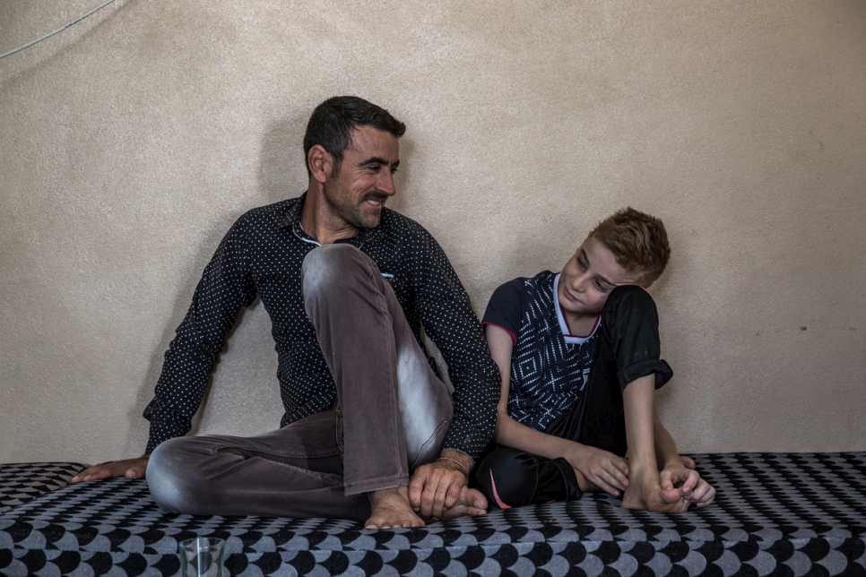 هادي تامو – 31 عاماً – يجلس مع ابن أخيه عماد في منزلٍ في دهوك، كردستان العراق.
