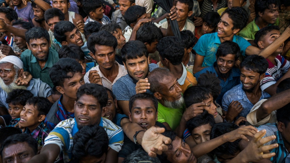 Newly arrived Rohingya refugees scramble for clothing being distributed from an aid truck in the Kutupalong Refugee Camp.