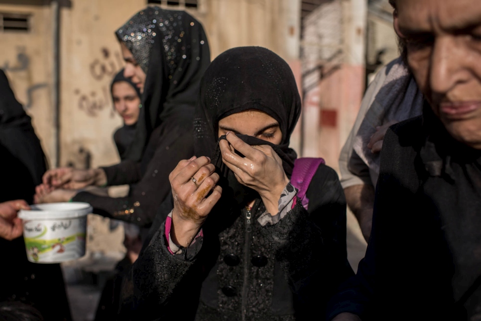 An Iraqi girl cleanses her face with water after reaching Iraqi government controlled area of Mosul, Iraq on June 23, 2017.