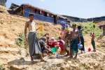 Rohingya refugee Anu Mia (left), age 30, struggles to get clean water ...