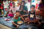 Thirty-year-old Onu Bala and her three children eat a meal at Hindu Pa...
