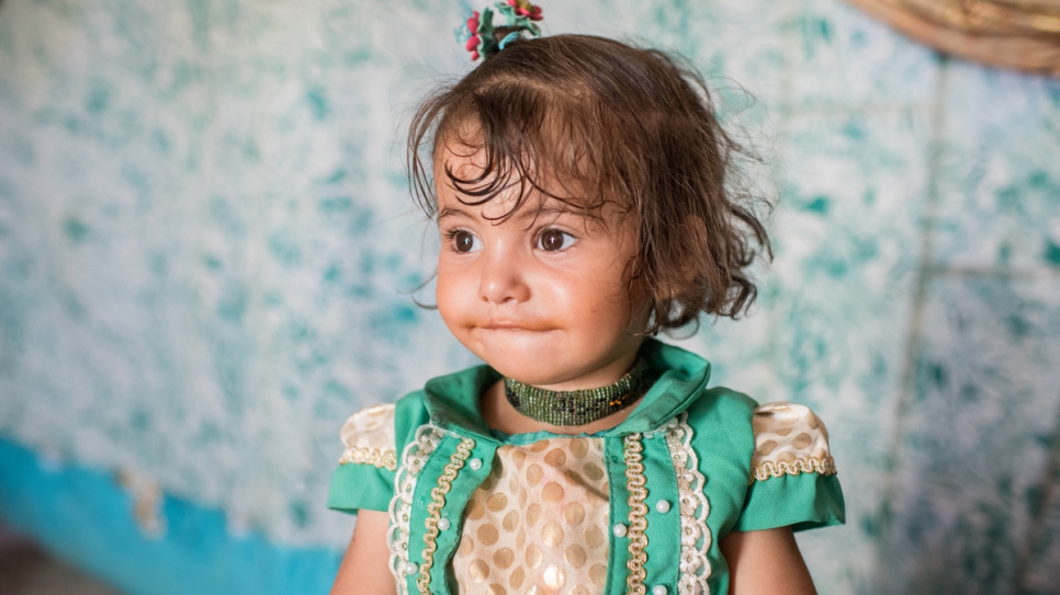 Bedoor, 2, plays in her tent at Hammam Al-Alil camp.