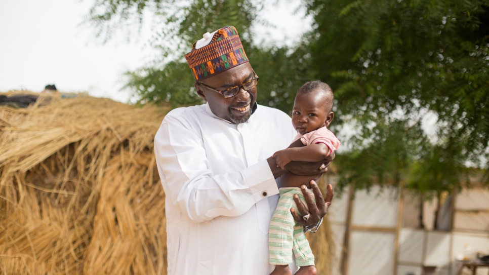 Mustapha tient dans ses bras le bébé Zannah à qui ses parents déplacés lui ont donné son propre nom. Cette famille déplacée vit près de la deuxième des deux écoles que Mustapha a créées à Maiduguri. 