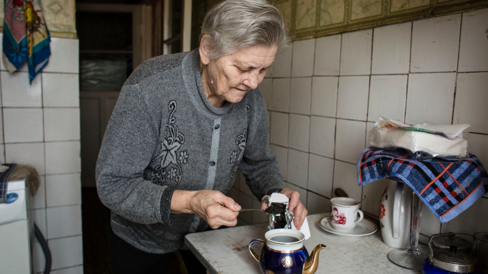 Hanna prépare du thé dans la cuisine de son appartement à Chtchastia. Malgré les dangers et les problèmes permanents, Hanna et Oleksiy, son mari malade, sont restés sur place depuis le début du conflit en avril 2014. 