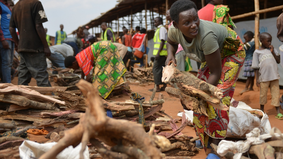 Charlene collects firewood for her family's new shelter at Mahama refugee camp.