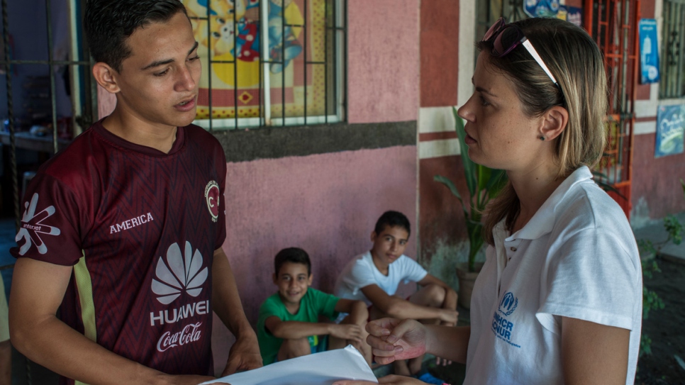 A UNHCR protection officer talks to Moises, Anderson and Jairo.