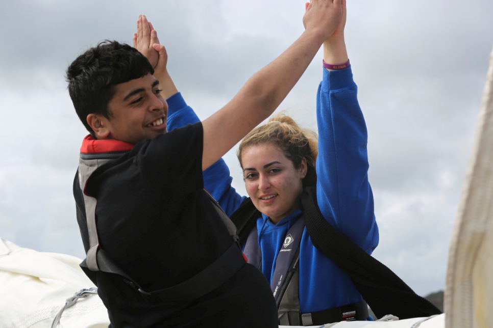 Caylan from Ireland and Omran from Syria learn how to sail together.