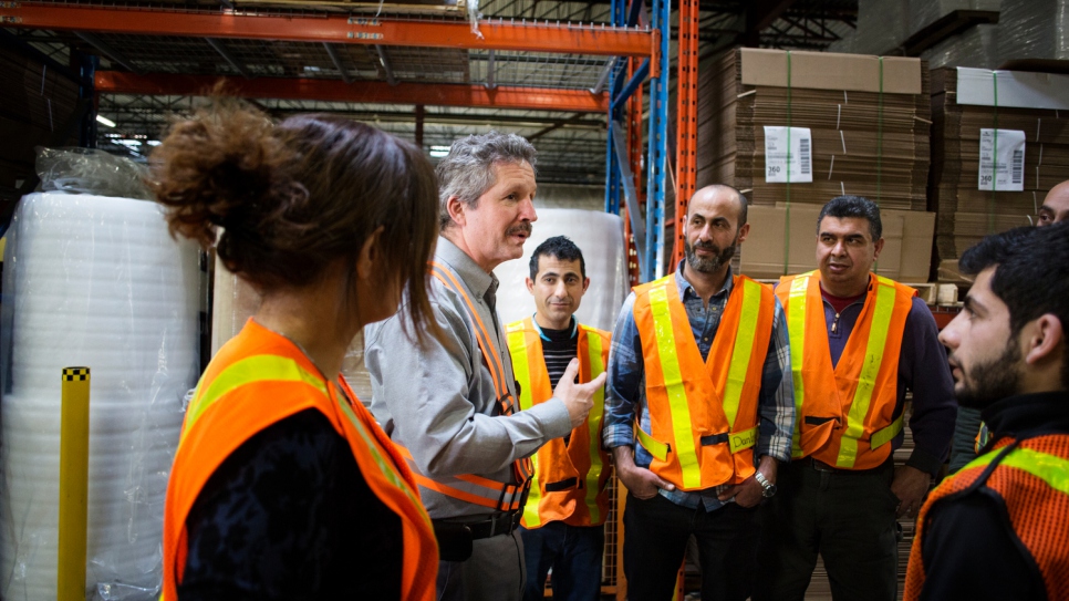 Jim Estill speaks with employees at the company warehouse.